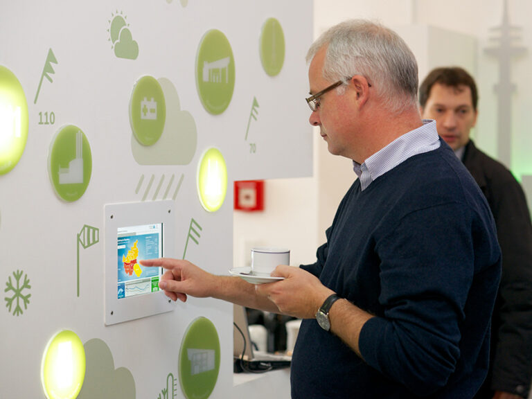 Foto eines Mannes vor einer interaktiven Wand im Inforaum in der HafenCity